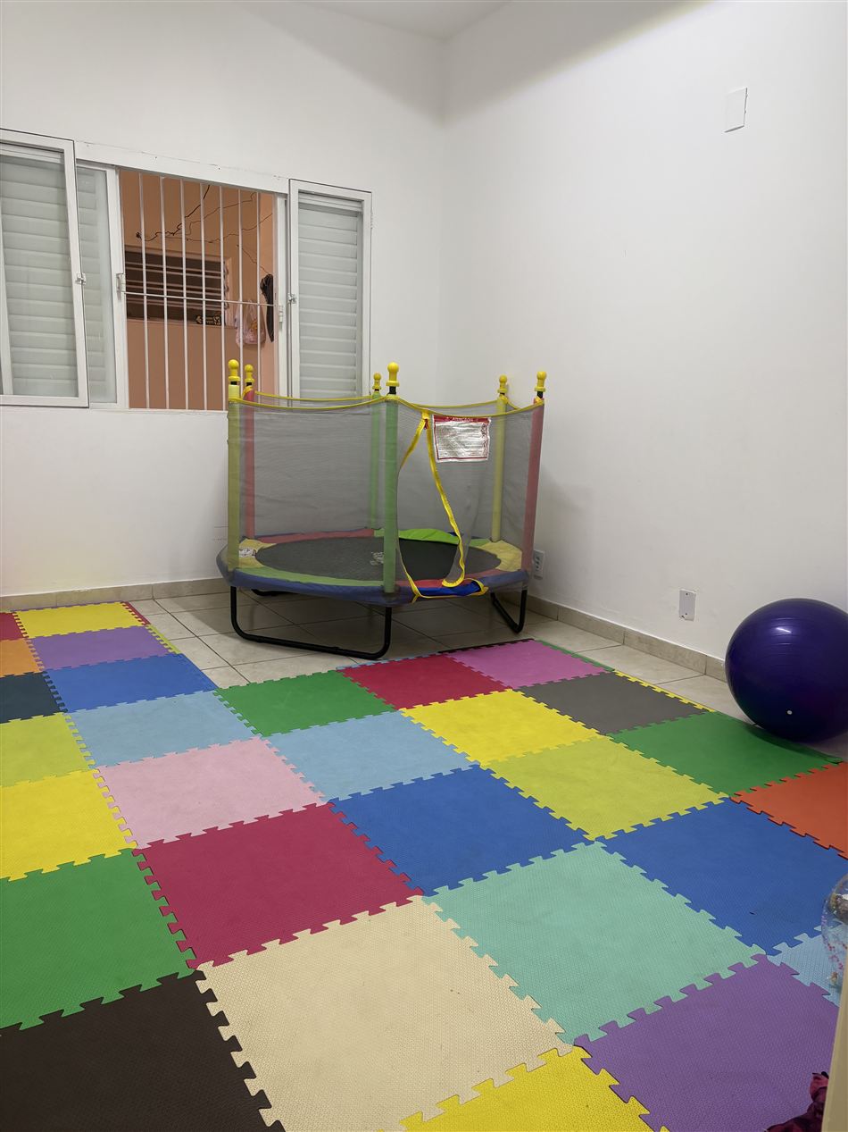 Sala de integração sensorial com tatame colorido e trampolim