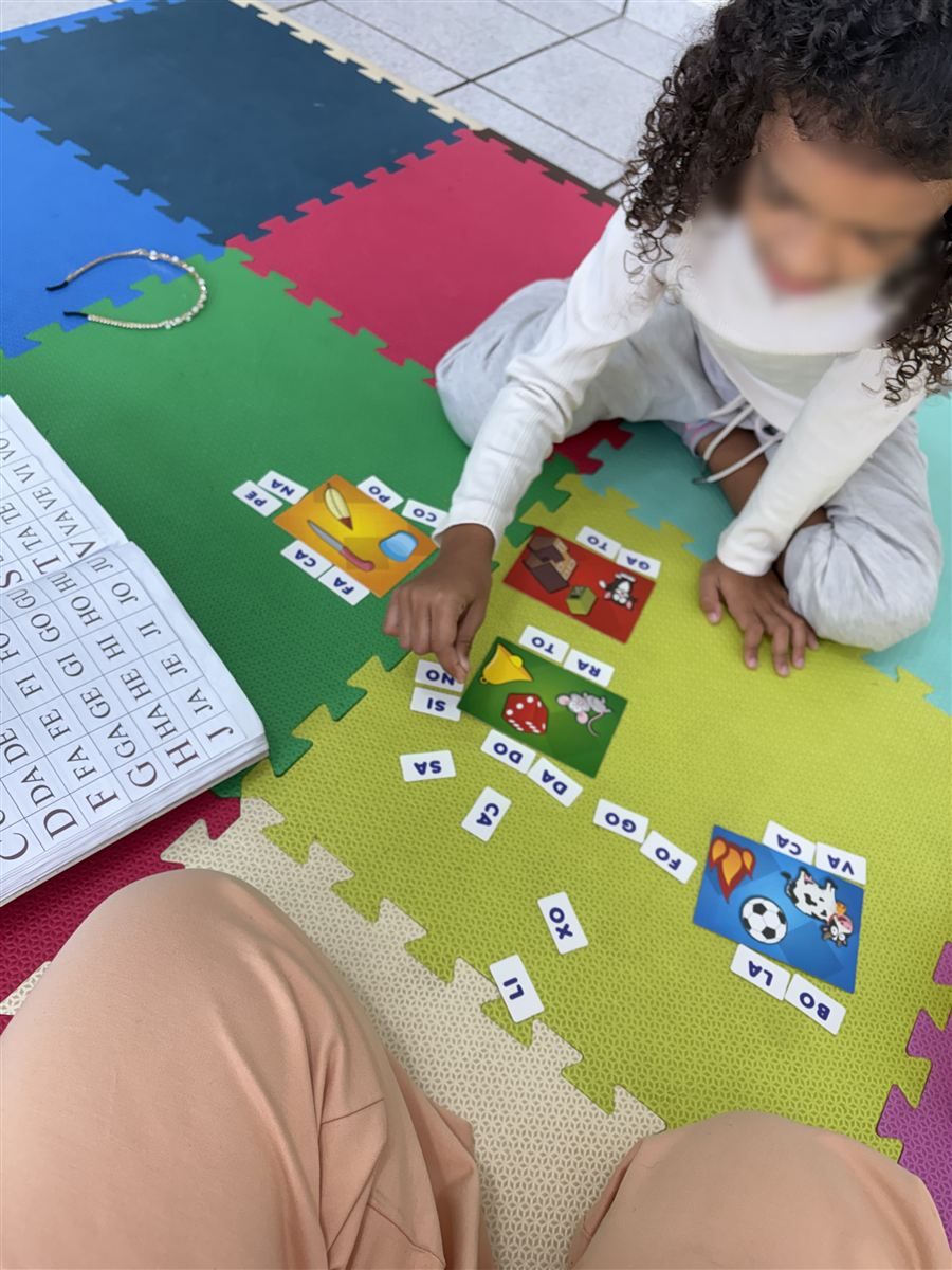 Criança montando palavras em jogo de sílabas