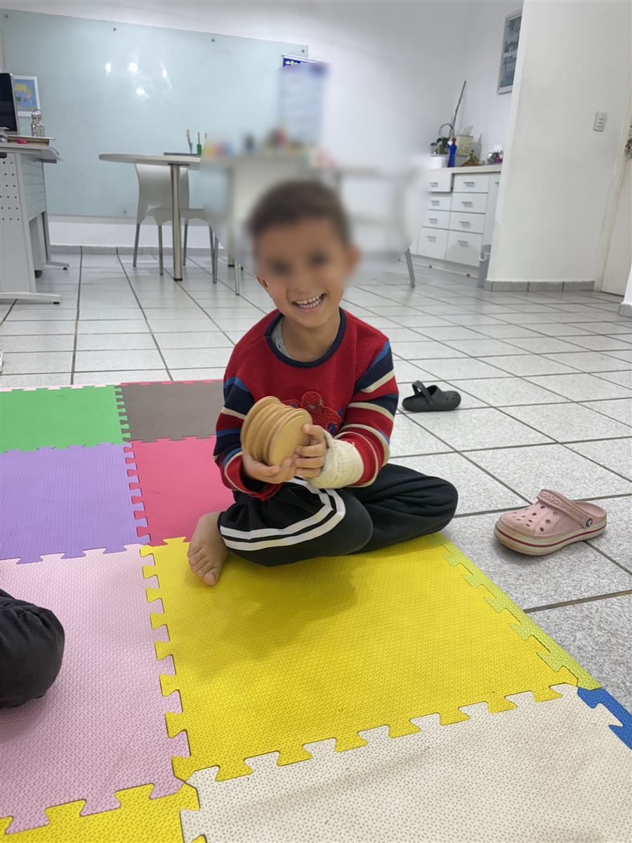 Criança sorrindo durante atividade motora