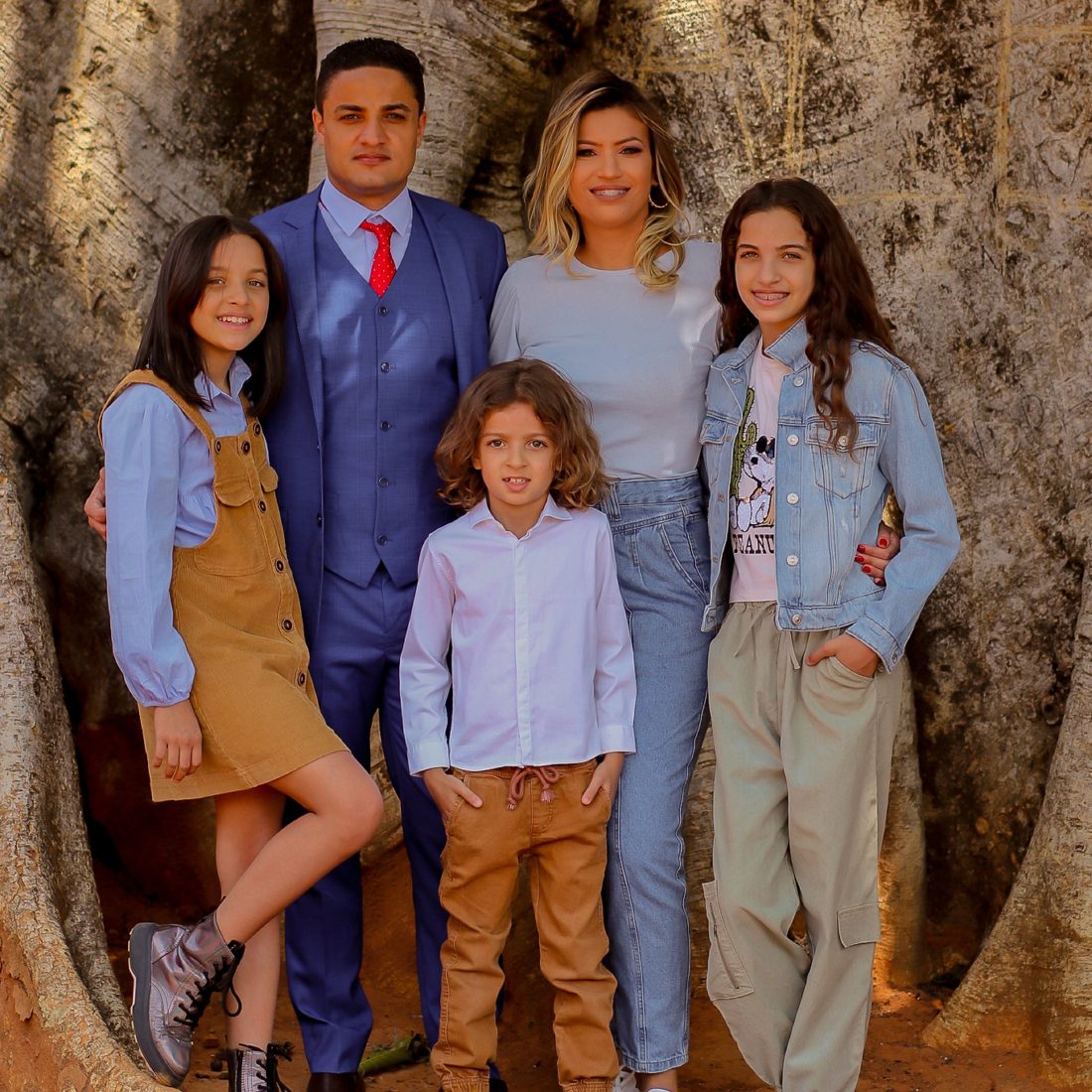 Família Fernandes reunida junto a uma grande árvore, símbolo das raízes e do crescimento do Espaço NeuroLearn